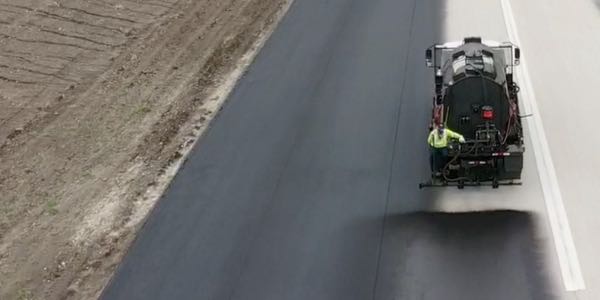 Stripe-It-Up crews apply fresh asphalt sealcoat to a private airport runway