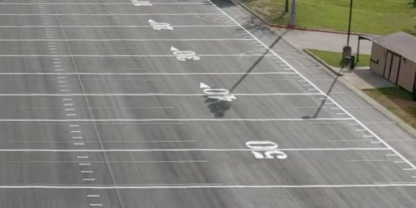 Parking lot striped with football field markings in central Texas